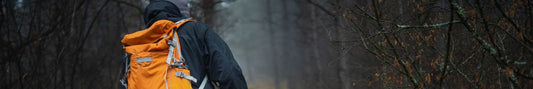 A man wearing a hiking jacket in the rain.