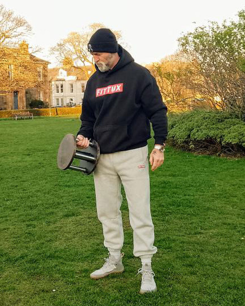 Dude wearing our premium black Fittux hoodie and grey tracksuit bottoms. 